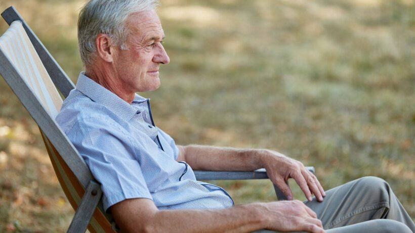 Mężczyzna z objawami POChP siedzi w ogrodzie na krześle